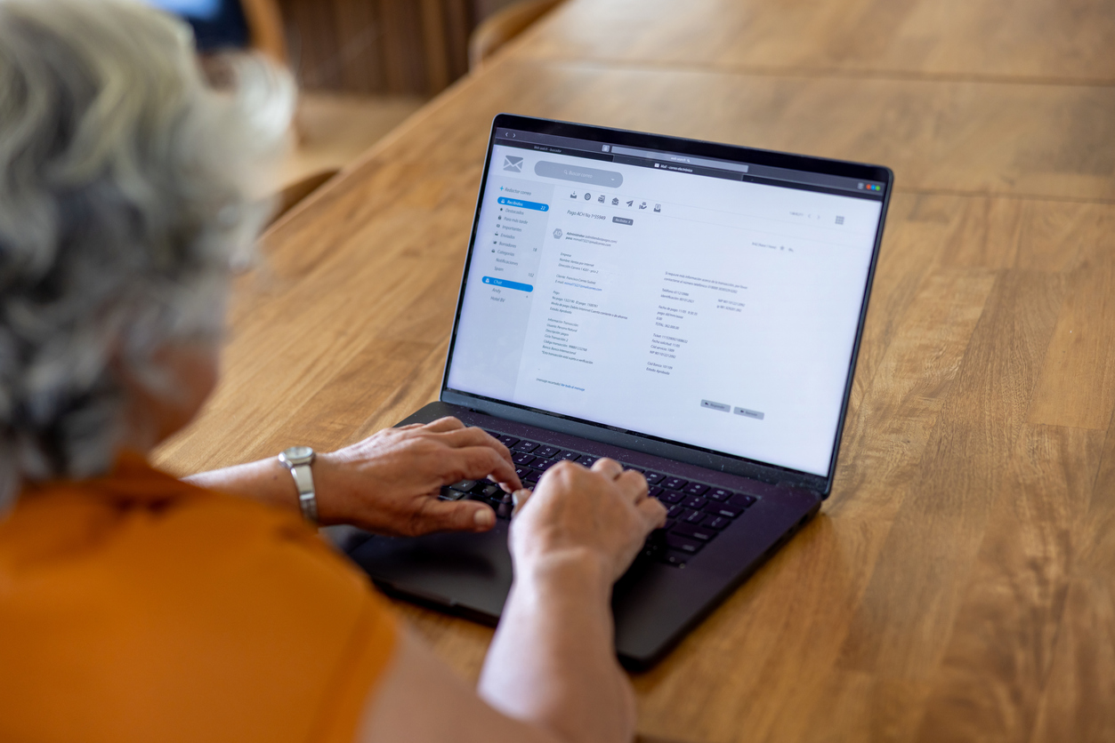 Senior woman at home checking her e-mail on her laptop stock photo