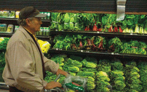 man pushing grocery cart in produce aisle