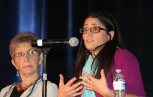 Mona Hanna-Attisha speaking into microphone as another woman looks on