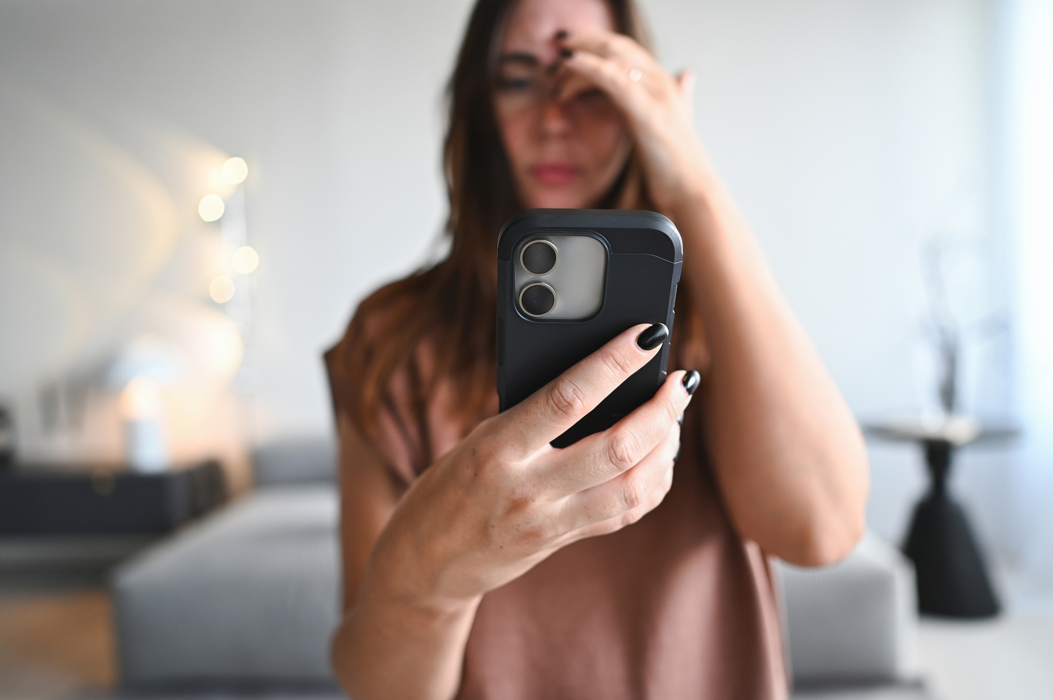 A woman frowning at her phone