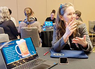 Christine Gannon sits at a table and speaks to people attending an APHA 2025 session on disability