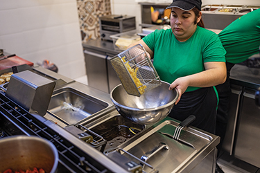 A fast food worker prepares French fries