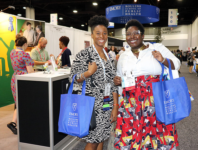 women smiling in front of Public Health Expo booth