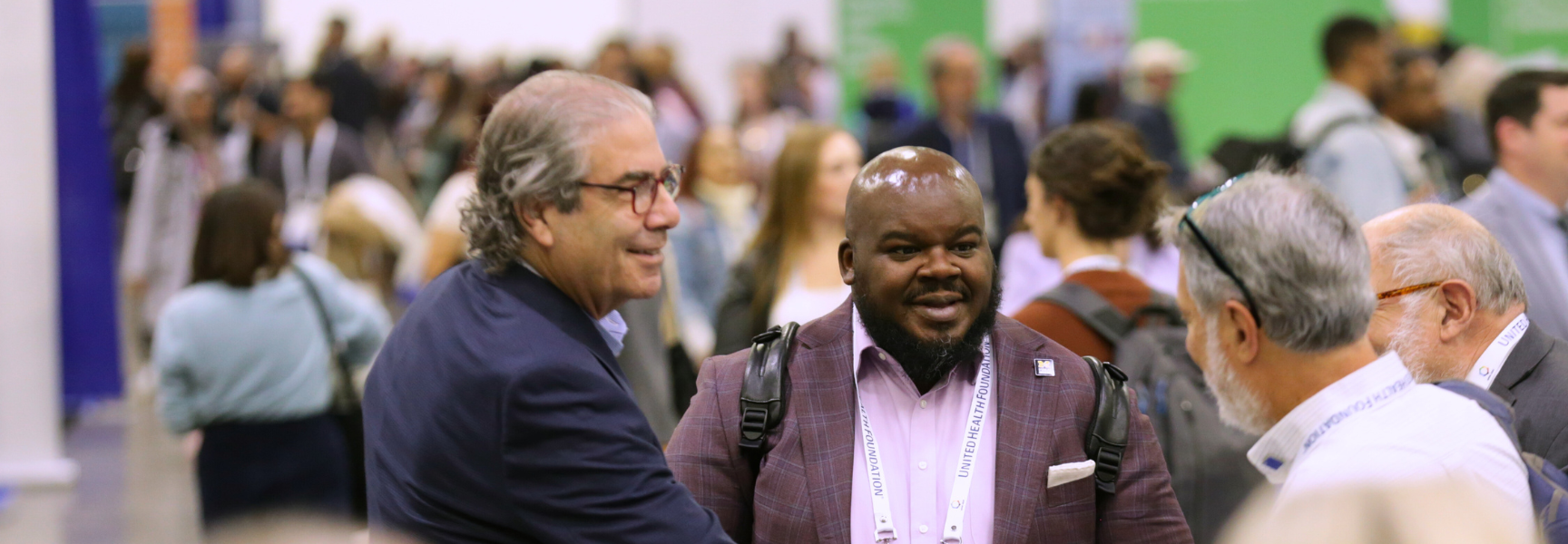 Three men meeting at the annual meeting and shaking hands