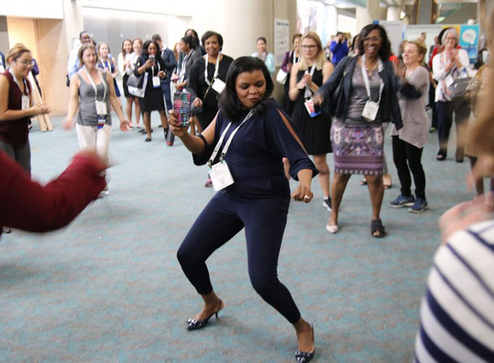 woman dancing in center of group of people