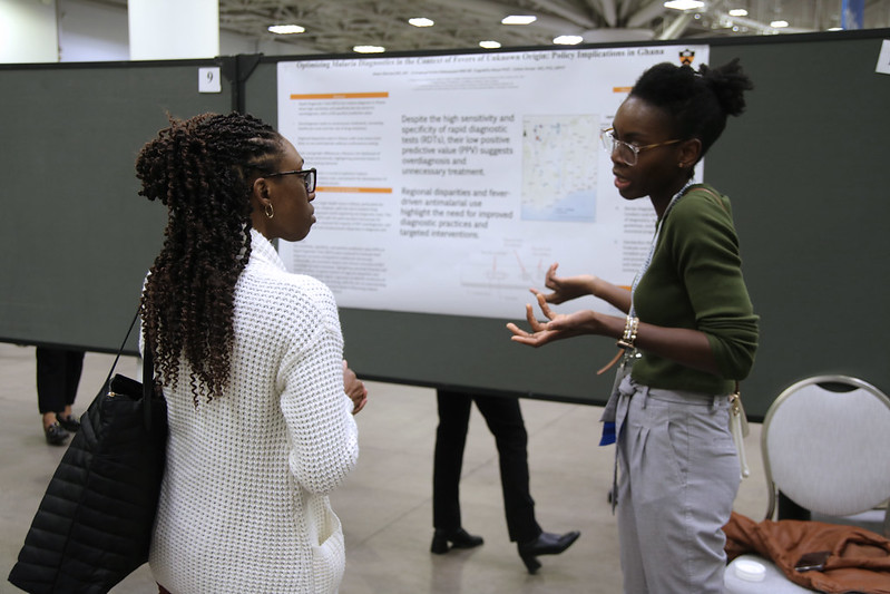 Two women giving a poster presentation at APHA annual meeting