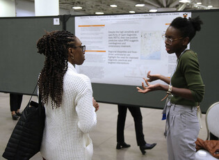 Two women giving a poster presentation at APHA annual meeting