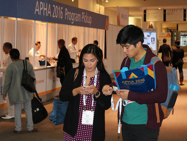 man and woman check phones near registration area